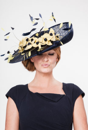 Large navy sinamay hat with yellow hand sewn flowers and navy coque feathers